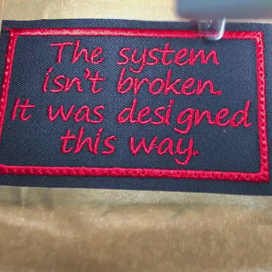 The System Isn't Broken Patch – Red Embroidery on Black Twill – Political Protest Patch